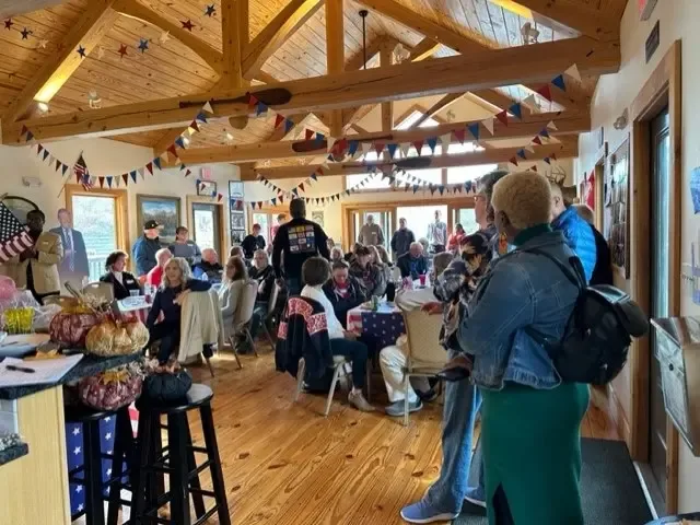 A crowded hall decorated with red, white and blue bunting